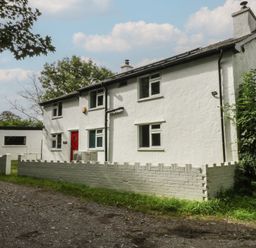 A house with a red door and white fence at Neuadd Wen in Gaerwen