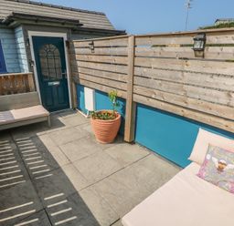 An outdoor area with a bench and planter at Awel Deg, Tresaith