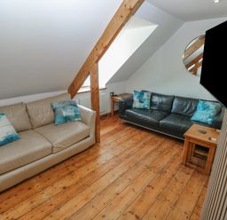 A living room with sofas and a coffee table at Awel Deg, Tresaith