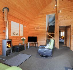 A living room with wooden wall and stove at Trevano in St Breward
