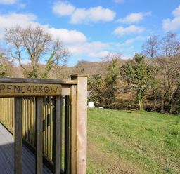 A view of a wooden railing with a sign at Pencarrow in St Breward