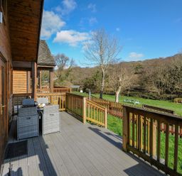 An outdoor area with a deck, table and chairs at Trebah in St Breward