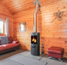 A living room with a fireplace and sofa at Trebah in St Breward