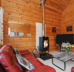A living room with a fireplace and sofa at Polzeath in St Breward