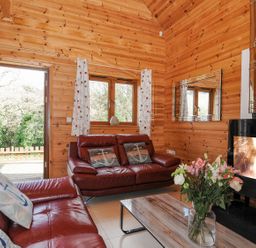 A living room with a sofa and fireplace at Polzeath in St Breward