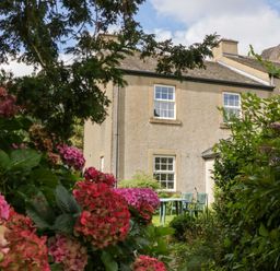 A house with garden furniture surrounded by flowers at Buckbarrow in Seascale