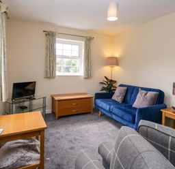 A living room with a sofa and side tables at Buckbarrow in Seascale