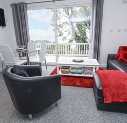 A living room with a sofa and dining area at I C Lundy Too Bideford Bay Holiday Park near Woolfardisworthy