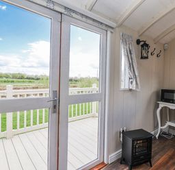 A room with a door and window overlooking the landscape at The Dragonfly in Bewholme near Hornsea