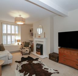 A living room with a fireplace and television at Cariad Cottage in Hereford