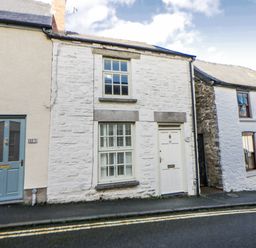 A house with a white facade and a blue door at Cariad Cottage in Hay-On-Wye