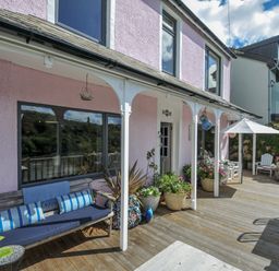 An outdoor area with a bench and plants at Mayhurst in Looe