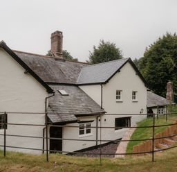 An exterior view of a house with a chimney and steps at Holwell Farmhouse in Bampton