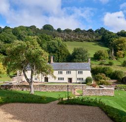 A house with a garden and tree at Holwell Farmhouse in Bampton