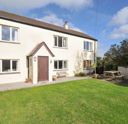 A house with a garden and seating area at Rosewin Farmhouse near St Minver