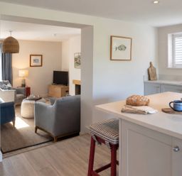 A kitchen with a view of the living area at Wood Cottage