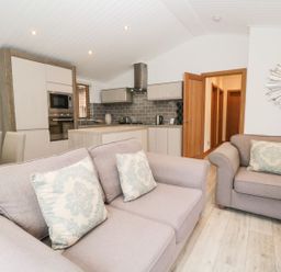 A living room with sofas and a dining area at Easedale Lodge, Waterside Wood 2, White Cross Bay near Windermere
