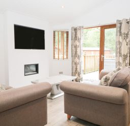A living room with a television and sofa at Easedale Lodge Waterside Wood 2 White Cross Bay near Windermere