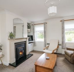 A living room with a fireplace and sofa at Dunbrody Dreams
