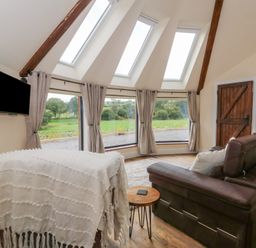 A living room with a sofa and television at Yr Awen in Lampeter