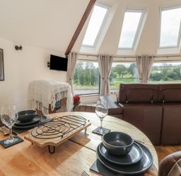 A dining room with a table and chairs at Yr Awen in Lampeter
