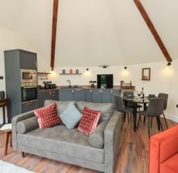 A living room with a kitchen unit and dining area at Y Cwlwm in Lampeter