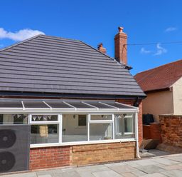 A conservatory with a brick wall and chimney at Floraville