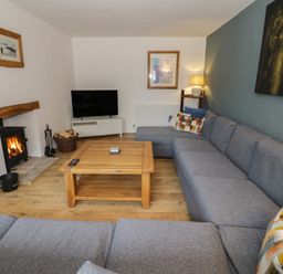 A living room with a tv and a fireplace at Harran in Pershore