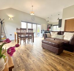 A living room with a sofa and dining area at Dwrgi Aber near Llanybydder