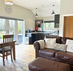 An open plan living and dining area with a dining table and sofa at Dwrgi Aber near Llanybydder