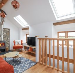 A living room with a sofa and fireplace at The Old Dairy in 
