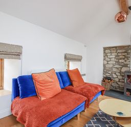 A living room with a blue sofa and a fireplace at The Old Dairy