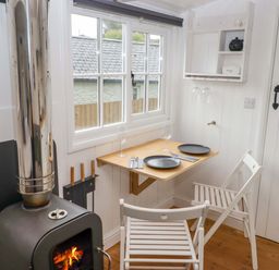 A dining area with a table and chairs at Shepherd's Hut in Perranarworthal