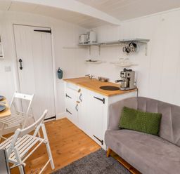 A kitchen with a coffee machine and table at Shepherd's Hut in Perranarworthal