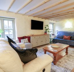 A living room with a sofa and coffee table at Penally Mews in St Dogmaels