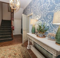 A hallway with a staircase and console table at The Boundary in Windermere