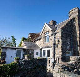 A stone house with a wall and steps at The Ingle in Barmouth