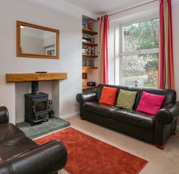 A living room with a fireplace and bookshelf at Cloud Cottage in Ambleside