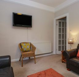 A living room with a television and sofa at Cloud Cottage in Ambleside
