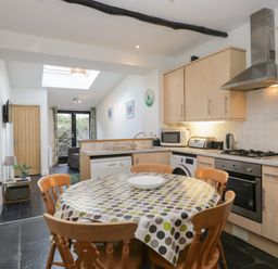 A kitchen with a dining table and appliances at Cloud Cottage in Ambleside