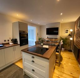 A kitchen with an island and seating at Dolwen in Caernarfon
