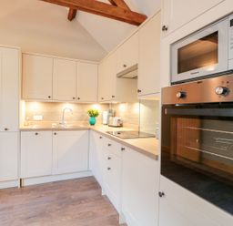 A kitchen with cabinets, sink, and appliances at The Old Sorting Office