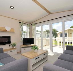 A living room with a sofa and television at Eden Way 47