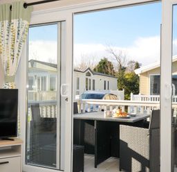 A living room with glass doors leading to an outdoor area at Eden Way 47 Par