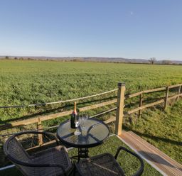 An outdoor space with table and chairs overlooking a field at GiGi's Horsebox Evesham