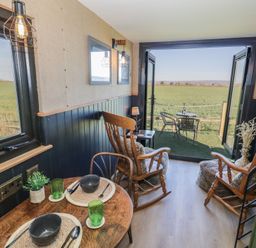 A living room with rocking chairs and a view of fields at GiGi's Horsebox in Evesham