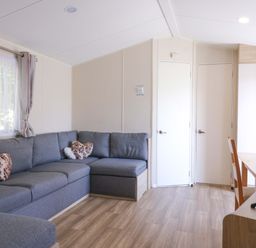 A living room with a sofa and dining table at Singh and Leite Family Caravan, St. Osyth
