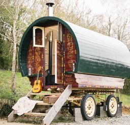 A caravan with a guitar outside and chimney at Goldfinch in Launceston