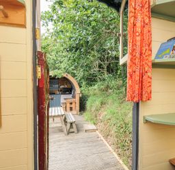 A view of an outdoor area with a table and benches at Goldfinch Panson Mill near Ashwater