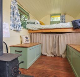 A bedroom with a lofted bed and benches at Prudence in Panson Mill near Ashwater